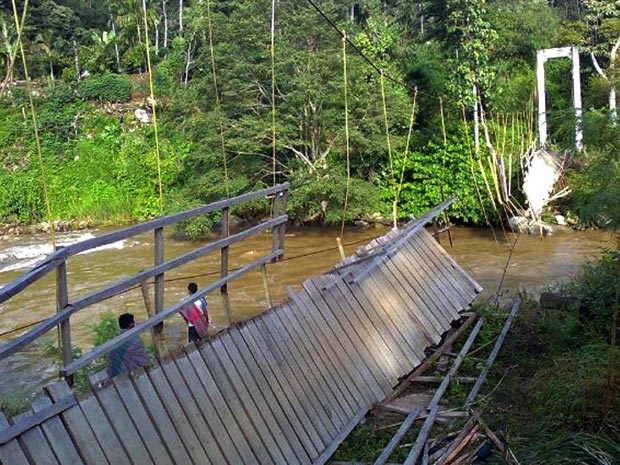 Moradores observam nesta segunda-feira (7) a ponte que desabou na Indonsia.