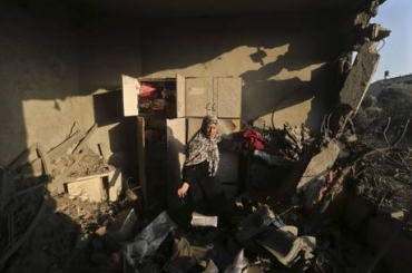 Mulher caminha entre escombros na Faixa de Gaza