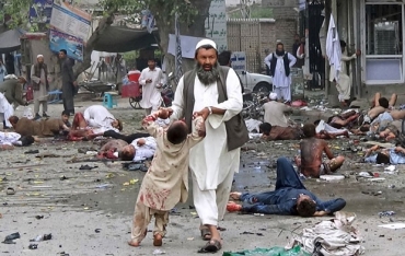 Homem retira criana querida de local de exploso em Jalalabad neste sbado (18) 