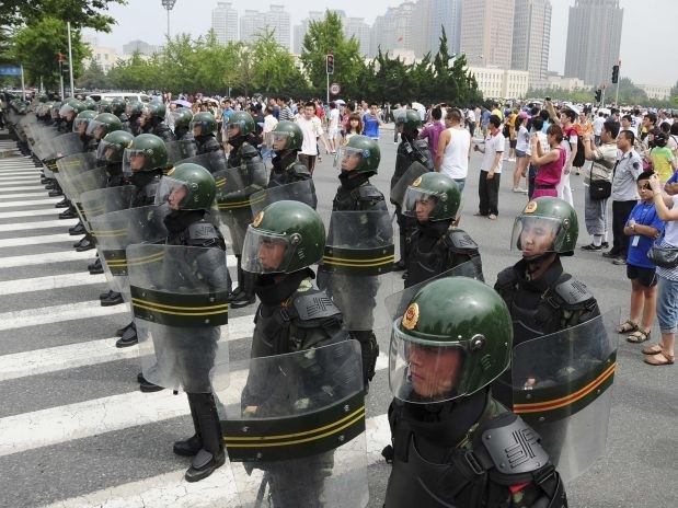 Policiais montam guarda em torno de manifestantes na cidade de Dalian