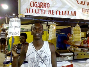 Ambulante aluga o celular para os folies por R$ 2 