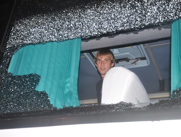 Adilson, volante do Grmio, observa janela do nibus quebrada