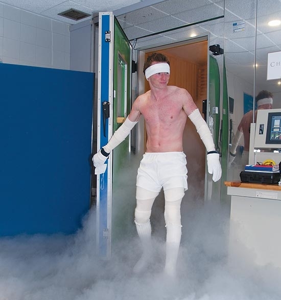 Vermelho de frio, o piloto de corrida Mike Cowan entra no espao climatizado da terapia com o modelito obrigatrio, que