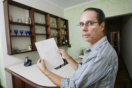 Francisco Magazoni em sua casa com a liminar que garantiu sua volta ao trabalho aps ser demitido pela USP
