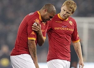 Adriano coloca a mo na regio perto do ombro direito observado pelo zagueiro noruegus da Roma John Arne Riise