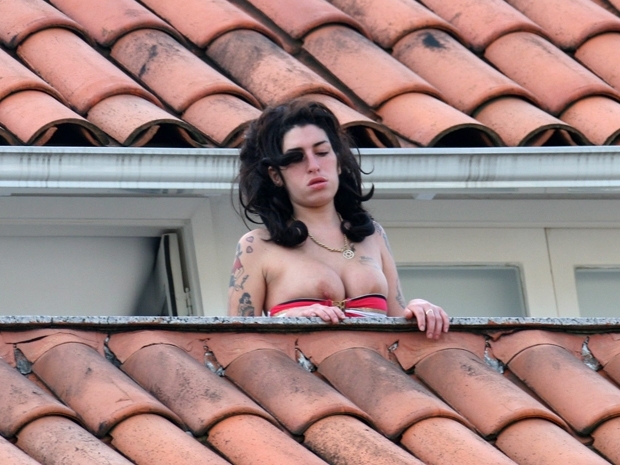 A cantora britnica Amy Winehouse, que roubou bebidas de quarto, na sacada de seu hotel em Santa Teresa