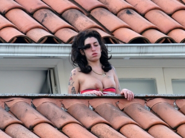 A cantora britnica Amy Winehouse, que roubou bebidas de quarto, na sacada de seu hotel em Santa Teresa 