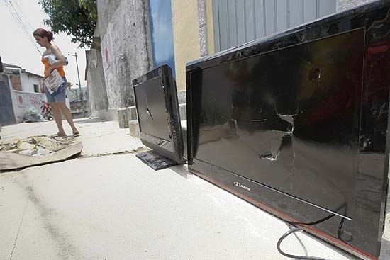 Moradores do Complexo do Alemo mostram TVs LCD que, segundo eles, foram quebradas por policias