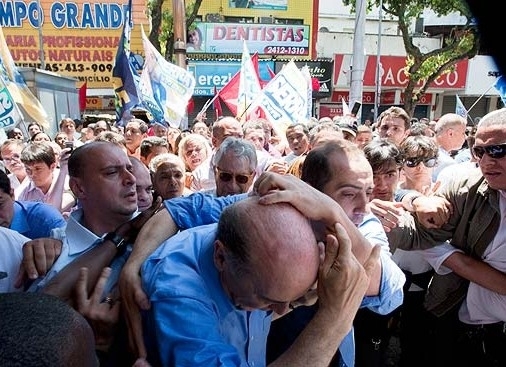 Jos� Serra protege a cabe�a ap�s levar pancada durante confus�o com militantes do PT em caminhada na zona oeste do Rio