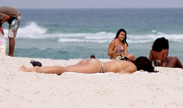A atriz Isis Valverde, que desamarrou a parte de cima do biquni na praia da Barra da Tijuca, no Rio de Janeiro  