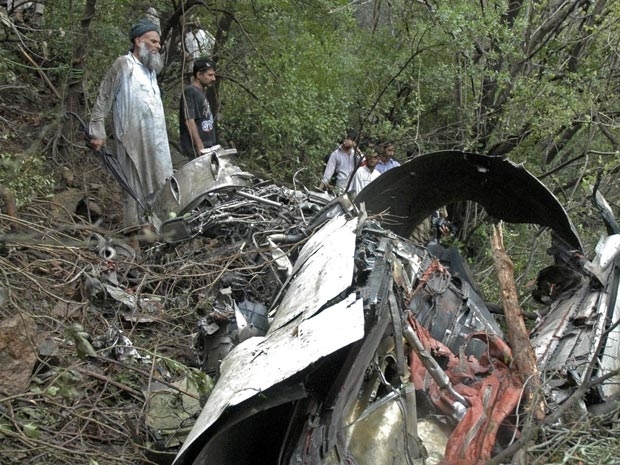 Equipes trabalham entre os destro�os do acidente pr�ximo a Islamabad nesta quarta-feira (28).