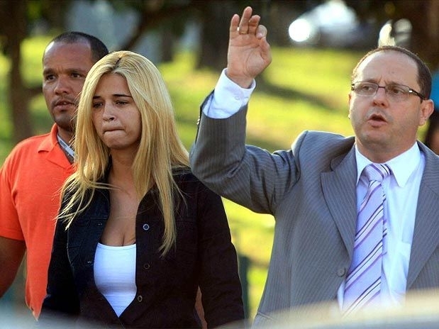 Fernanda Gomes Castro chega ao DIHPP ao lado do advogado Ercio Quaresma