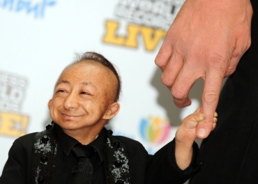 He Pingping, o homem mais baixo do mundo, segura m�o de Sultan K�sen, o mais alto 