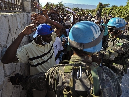 Soldados brasileiros barram um grupo que protestava perto do aeroporto de Porto Prncipe.