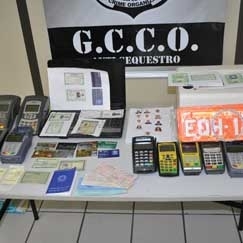 O delegado Flvio Stringueta observa os equipamentos de falsificao apreendidos com Nei Marcos Nunes