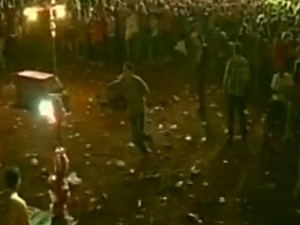 No centro da imagem, rapaz aparece correndo com a mo no peito, aps ser atingido por tiro