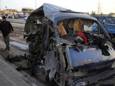 Iraquiano observa veculo destrudo aps exploso no bairro de Sadr, em Bagd