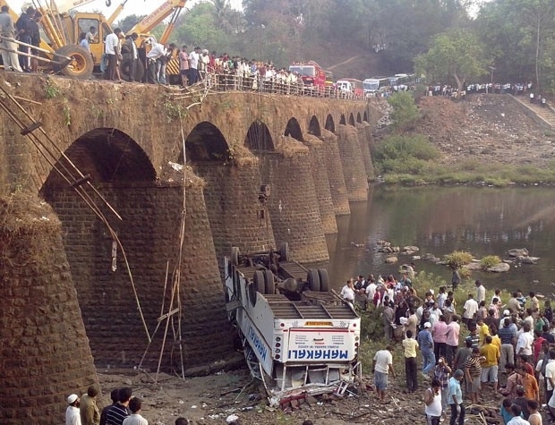 Resgatistas e passantes observam destroos de nibus que caiu de ponte no distrito de Ratnagiri, no estado indiano