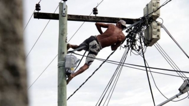O homem se arrisca passando no meio dos fios de alta tenso