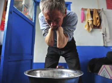 Sem as pr�teses, Sun Jifa lava o rosto