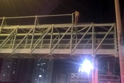 A pessoa sobre a passarela da Avenida Fernando Correa
