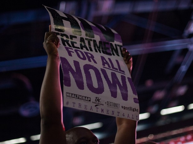 Ativista segura um cartaz pedindo tratamento para todos com HIV