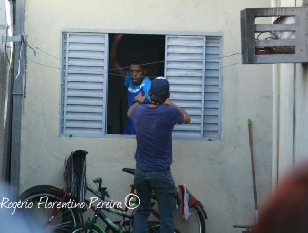 Policial tenta retirar o suspeito, Andr, pela janela da casa onde ele se escondia