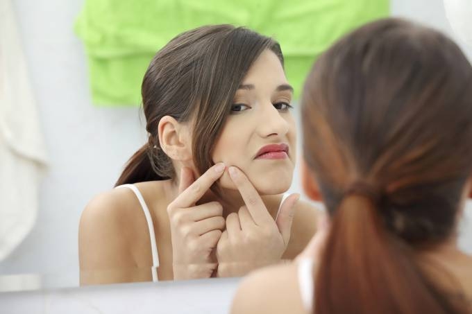 Mulher espremendo espinha (iStock/Getty Images)