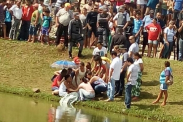 O corpo da adolescente � retirado de dentro da lagoa, em Vila Rica