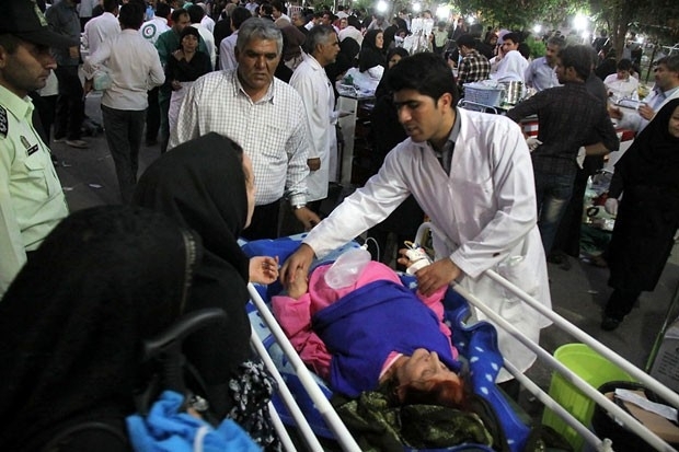 Mdico atende mulher ferida do lado de fora de hospital em Ahar, cidade iraniana afetada por terremoto neste sbado (11)