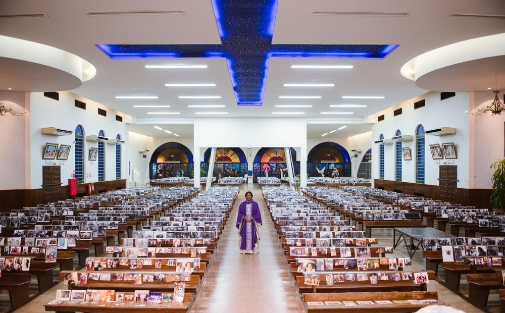 Frei Luciano de Souza Santos, na igreja vazia, com as fotos dos fieis espalhadas na igreja  Foto: Arquivo pessoal
