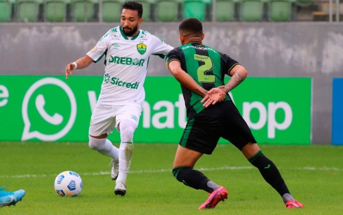 Atacante Clayson, do Dourando, em confronto com a defesa do Amrica-MG na partida