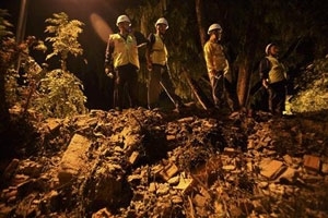 Equipe de resgate do Nepal observa os escombros do prdio da embaixada do Reino Unido que desabou em cima de um carro.