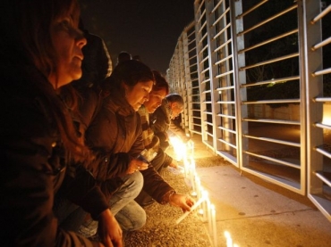 Pessoas acendem velas em frente � emissora de TV, que tem cinco de seus funcion�rios no avi�o desaparecido, inclusive o 