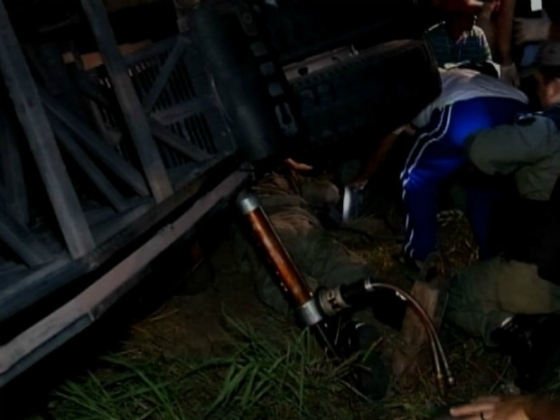 Bombeiro (macaco cinza) entra embaixo do nibus para retirar vtimas presas nas ferragens.