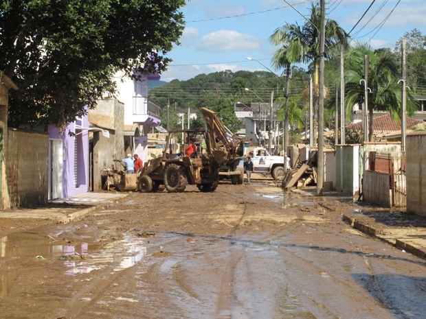 Trator retira lama aps cheia do rio