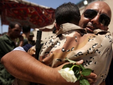 Refugiados s�o abra�ados ap�s chegada a Benghazi.