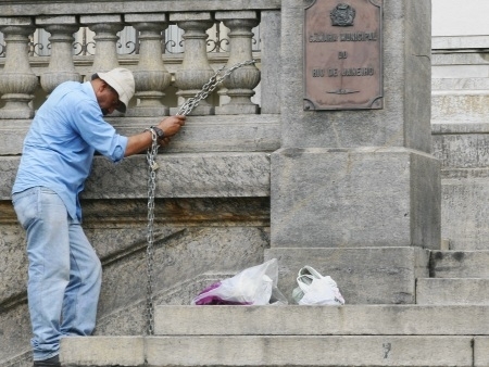 Homem est acorrentado para protestar contra compra de carros